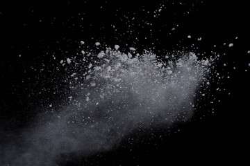 White powder explosion on black background. Dust splatted isolated. Paint Holi.