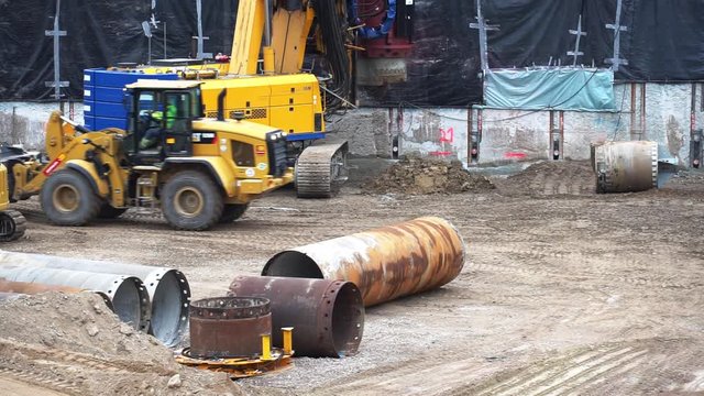Jumbos Spielzeug - Radlader bewegt Stahlr&ouml;hre, die zum Bau von Punktfundamenten verwendet wird