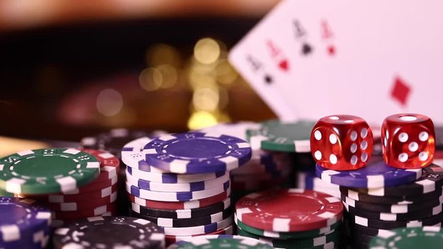 Poker Chips on gaming table, roulette wheel in motion