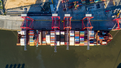 Aerial view with the container ship of the drone is loading in a harbor. Cenital plane.