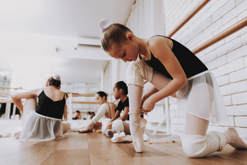 Young Girls Preparing for Ballet Training Indoors.