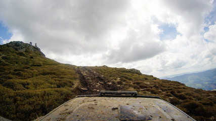 Travel by car in Ukrainian Carpathians. Hood car and mountain view. Offroad