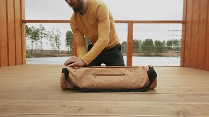 Man opening Bag with mat and accessories for yoga, pilates and fintess - Powered by Adobe