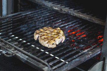 Piece of meat roasts on a grill / Shot of a oven with a meat cooking in it
