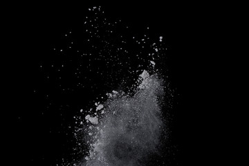 White powder explosion on black background. Dust splatted isolated. Paint Holi.