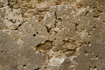 Detail of a very rough and aged stucco wall.