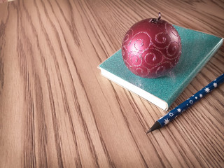 Fototapeta premium Christmas background with blank notebook,pencil with stars on the wooden table