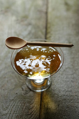 Young light floral honey and a wooden spoon.