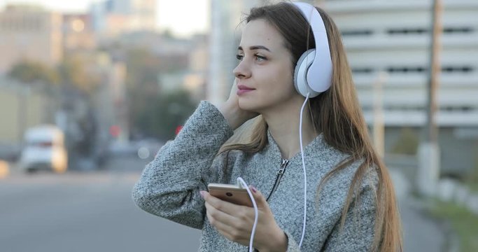 Woman listening to music with headphones in city