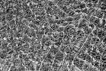 Black and white texture based on the glare of the surface of the water in the fountain_