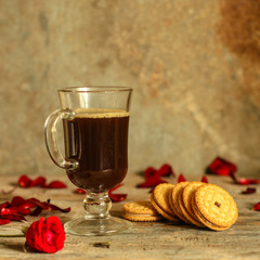 coffee in a transparent cup and roses on the table (brewed tea bag). top view.