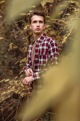 Handsome young guy in nature on an autumn day