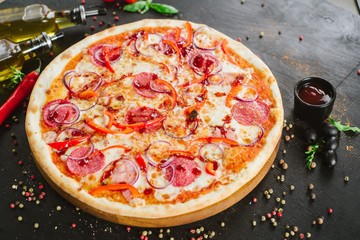 Delicious classic meat pizza on black background