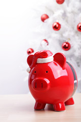 Piggy bank in front of a white Christmas tree