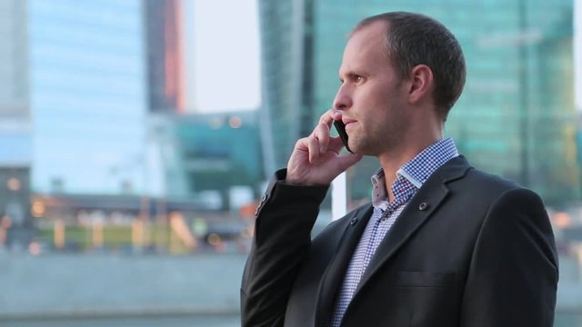 Man on smartphone - young business man talking on smart phone. Casual urban professional businessman using mobile cell phone