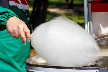Fototapeta na wymiar Making white cotton candy in cotton candy machine close-up
