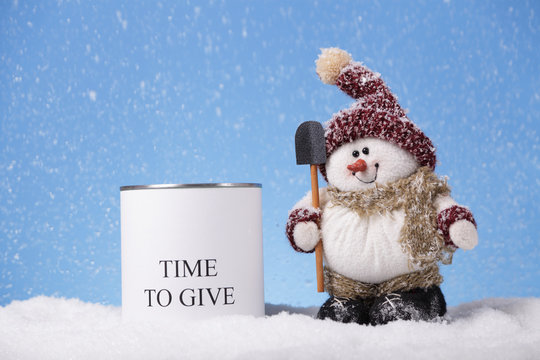 Snowman next to a tin can for Christmas donations