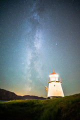 Beautiful Night Sky Milky Way Stars Galaxy with Lighthouse on Ocean Water Coast in Norway Scandinavia