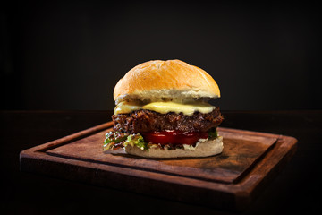 Delicious hamburger isolated in a wooden table with a black background