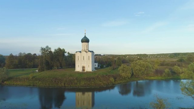 Church of the Intercession on the Nerl River at Sunny Evening. Vladimir Region, Russia. Aerial View. Drone is Orbiting Around