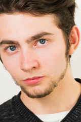 Obraz premium Handsome young man's face. Portrait of cheerful young guy isolated on a white background.