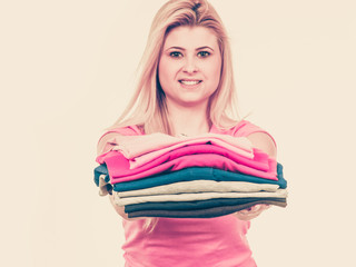 Woman holding pile of folded clothes