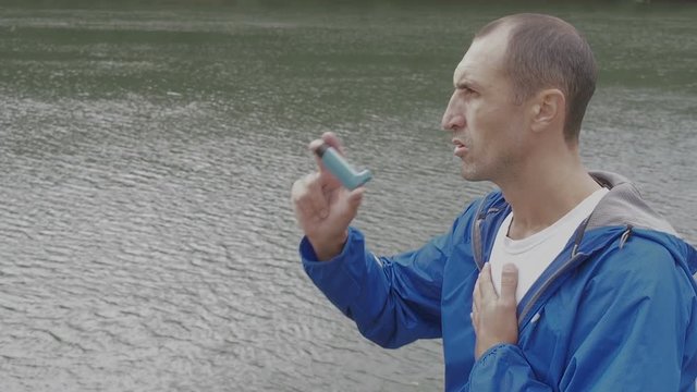 Asthma. Asthma attack. A man with an inhaler on nature.