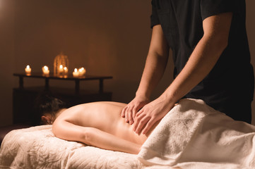 Close-up of male hands. Masseur does massage for the waist of a young girl. Rehabilitation, beauty therapy medicine. healthy concept