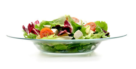 Plato de cristal con ensalada en su interior visto frontalmente y sobre un fondo blanco