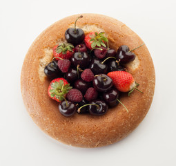 Bizcocho savarín relleno de fresas, frambuesas y cerezass visto cenitalmente