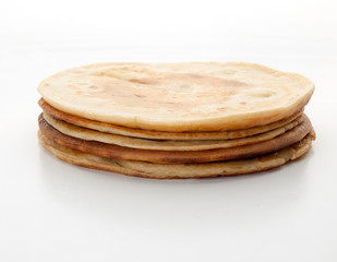 Varias tortitas americanas redondas apiladas sobre un fondo blanco