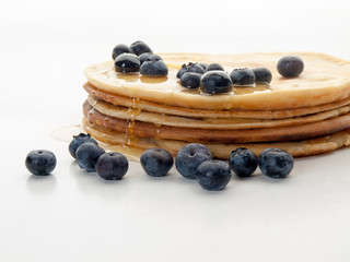 Varias tortitas americanas decoradas con miel y arándanos