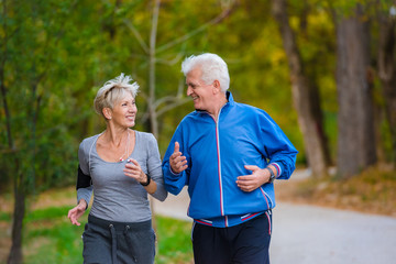 Smiling senior couple jogging in the park