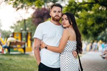 Handsome guy hugging his girlfriend in the park.