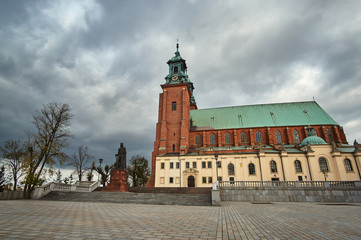 Fototapeta na wymiar Statue and Gothic cathedral church in autumn in Gniezno .