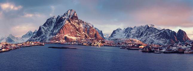 Amazing view to the winter Reine village at pink sunrise. Northern Norway, Lofoten Islands. Panorama