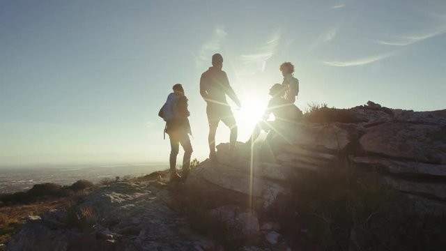 Friends resting on mountain top during hike