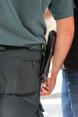 policeman wearing a pistol in a belt holster, rear view