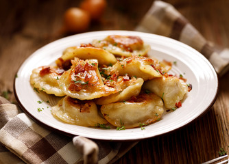 Fried dumplings stuffed with cabbage and meat sprinkled with bacon greaves and chopped parsley on a...