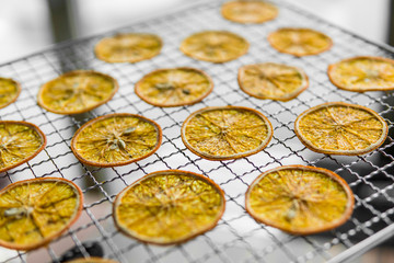 Candied orange slices on grid for drying. Dried fruits which can be used as a decoration to the meal or cocktails. Healthy vegetarian food rich on a vitamins and microelements.
