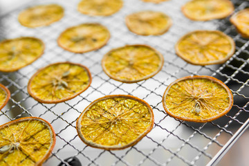 Candied orange slices on grid for drying. Dried fruits which can be used as a decoration to the meal or cocktails. Healthy vegetarian food rich on a vitamins and microelements.