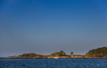 Scandinavian coastal landscape with sailing boat 