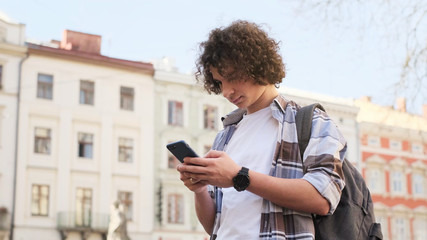 Happy guy using mobile in the street. Communication concept.