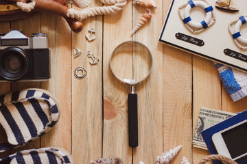 Piggy bank, phone, camera and maritime decorations, wooden background