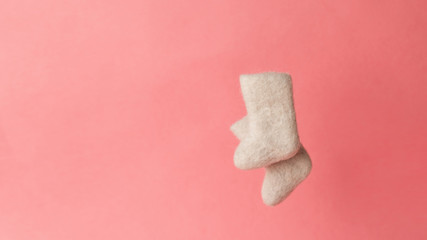 woolen warm winter shoes valenki on a pink background. the concept of winter. winter shoes