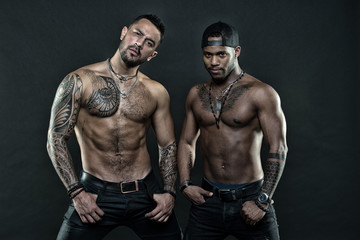 Men tattooed muscular body. Fashion models muscular chest. Sportsmen muscular belly posing. Sport and bodycare. Muscular and masculine guys look confident. African and hispanic men sexy bare torso - obrazy, fototapety, plakaty