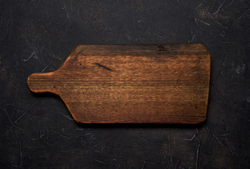 Empty old cutting board on a black background. Layout for the recipe.