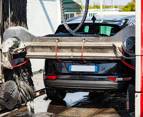 Fototapeta na wymiar Black car in automatic car wash