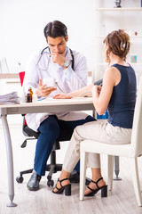 Young doctor checking woman's blood pressure