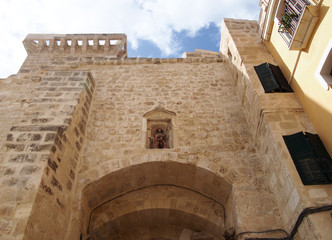 close up of the historic stone city gate in Mahon Menorca against a blue sunlit sky